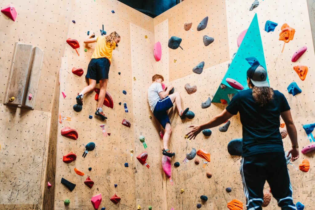 two kids climbing a rock wall