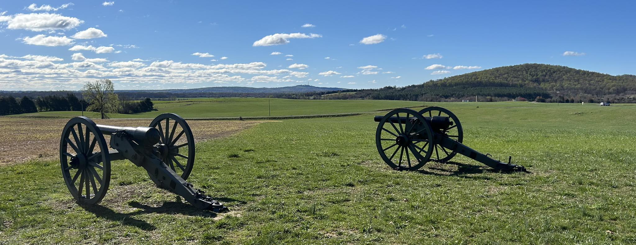 photo of two cannons sitting on a battlefield