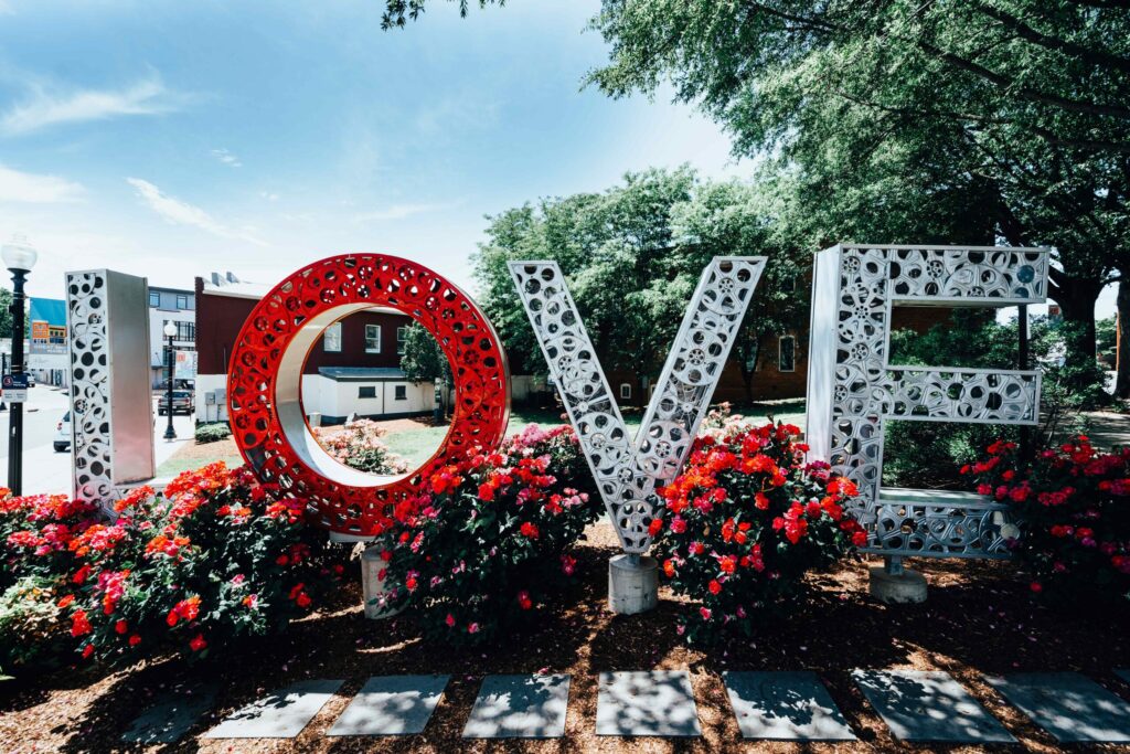 LOVE sign with red and pink flowers around it