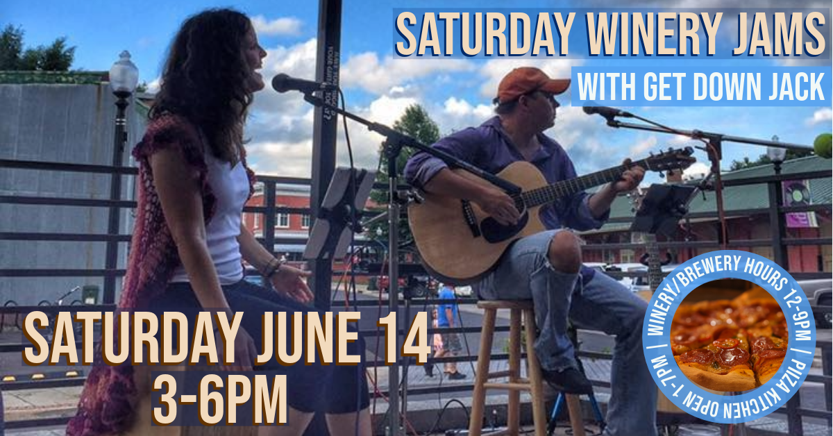 two people sitting on a stool singing, one with a guitar.