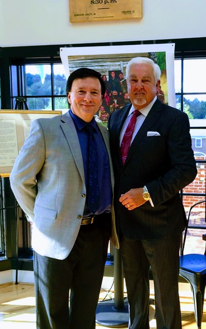 two men standing side by side dressed in business attire